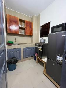 una cocina con refrigerador y estufa en Le doux refuge, en Abiyán