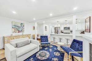 a living room with a couch and chairs and a kitchen at Luxurious Lincoln Park Home with Gourmet Kitchen in Chicago