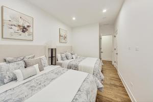 two beds in a bedroom with white walls and wood floors at Luxurious Lincoln Park Home with Gourmet Kitchen in Chicago
