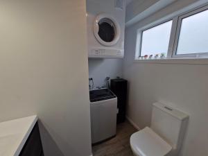a bathroom with a toilet and a sink and a window at Opononi Views -BRAND NEW! AMAZING VIEWS in Opononi