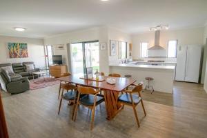 a kitchen and living room with a wooden table and chairs at Lakeside Living in Cuthbert