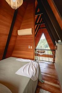 een slaapkamer met een bed in een kamer met een raam bij Kleines Paradies Chalés in Massaranduba +58 foto's