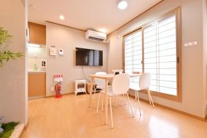 a dining room with a table and white chairs at Conveniently located for Tennoji Station, direct access to Kansai Airport, Japanese-style modern 3rooms, convenient shopping in Osaka