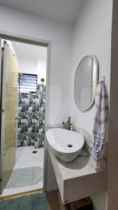 a white bathroom with a sink and a mirror at Inn the Mountain a farm house on a foggy farm hill in Cebu City