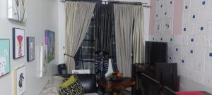 a living room with a chair and a window at Florida sun condo in Dasmariñas +3 photos