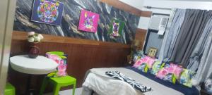 a bedroom with a bed and a desk and a table at Florida sun condo in Dasmariñas