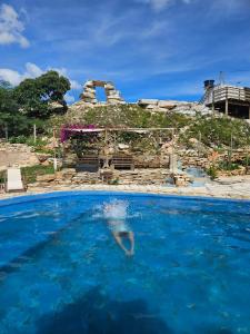 a person in the water in a swimming pool at Recanto das Pedras - Suíte 1 in São Thomé das Letras