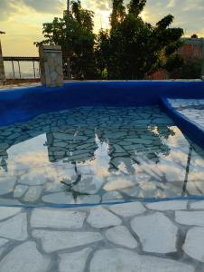a pool with a reflection of the sky in the water at Recanto das Pedras - Suíte 1 in São Thomé das Letras