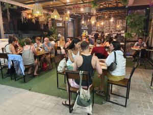 um grupo de pessoas sentadas em mesas em um restaurante em KohTaoHostel em Ko Tao