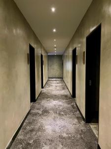 an empty hallway with black doors and a long corridor at BaBa Boutique House Langkawi in Pantai Cenang