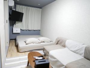 Una habitación con dos camas y una mesa y un televisor. en HOOD - Vacation STAY 19649v, en Amami