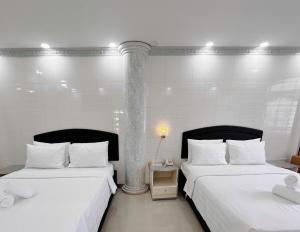 two beds sitting next to each other in a room at K&T Hotel - Center SaiGon in Ho Chi Minh City
