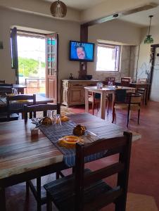 una sala da pranzo con tavoli e TV a parete di Recanto das Pedras - Suíte 2 a São Thomé das Letras