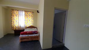 a small bedroom with a bed and a window at Mountain Majesty Homestay, Sombaria in Sombāri