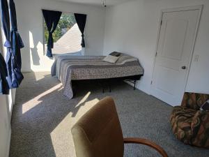 a bedroom with a bed and a chair and a window at Branson House Bed & Breakfast in Marion
