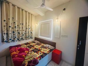 a bedroom with a bed with a quilt on it at balaji hotel & guest house in Rīngas