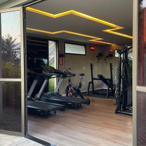 a gym with several tread machines in a room at Descanso e lazer in Parnamirim