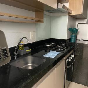 a kitchen with a sink and a stove at Descanso e lazer in Parnamirim