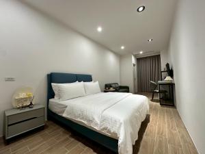 a bedroom with a large bed with a blue headboard at Neostay in Zhubei