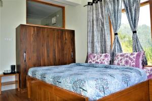 ein Schlafzimmer mit einem Holzbett mit Fenster in der Unterkunft Ridhi Sidhi Cottage Homestay in Shimla