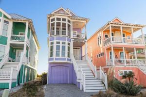 a row of colorful houses with a purple garage at Dolphin Dreams home in Atlantic Beach