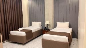 una habitación de hotel con dos camas y una mesa en Pedro's Hotel, en Sorsogon