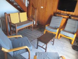 a living room with chairs and a tv and a table at Chalet Calme sur les Hauteurs - 8 Pers, Proche Pistes - FR-1-814-103 in Besse-et-Saint-Anastaise