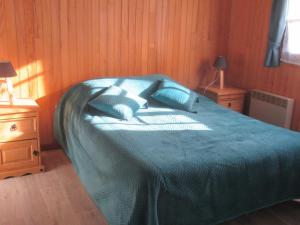 a bedroom with a bed with blue sheets and two lamps at Chalet Calme sur les Hauteurs - 8 Pers, Proche Pistes - FR-1-814-103 in Besse-et-Saint-Anastaise