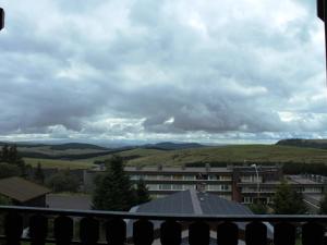 a view from the balcony of a building with mountains at Chalet Calme sur les Hauteurs - 8 Pers, Proche Pistes - FR-1-814-103 in Besse-et-Saint-Anastaise
