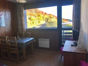 ein Esszimmer mit einem Tisch und einem großen Fenster in der Unterkunft Studio cosy sur les pistes, proche télécabines - FR-1-814-108 in Besse-et-Saint-Anastaise