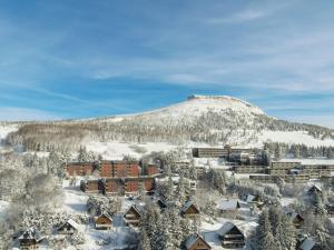 ein Resort im Schnee mit einem Berg im Hintergrund in der Unterkunft Studio central proche remontées mécaniques - FR-1-814-117 in Besse-et-Saint-Anastaise + 4 Fotos