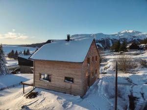 un piccolo edificio in mattoni con neve sul tetto di Chalet familial moderne à Super Besse pour 14 pers. - FR-1-814-121 a Besse-et-Saint-Anastaise