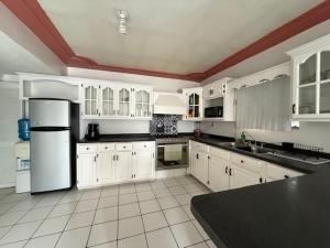a kitchen with white cabinets and a black counter top at Bonanza Casa de Huespedes in Ciudad Juárez