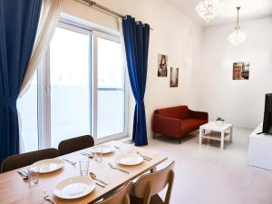 a dining room with a table and a large window at MK Residence JVC in Dubai