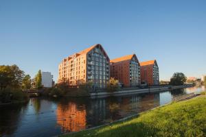a group of buildings next to a river at Staywin Dream Island in Gdańsk