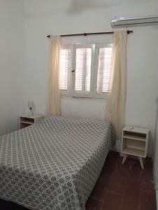 ein Schlafzimmer mit einem Bett und einem Fenster in der Unterkunft CASA PARA 4 PERSONAS, con asador y cochera in Cordoba + 9 Fotos