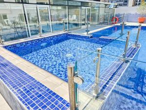 a large swimming pool with blue tiles in a building at MK Residence JVC in Dubai