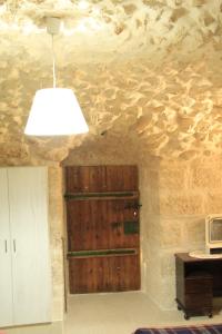 una camera con una parete in pietra e una porta in legno di Hosh Al Subbar a Bethlehem