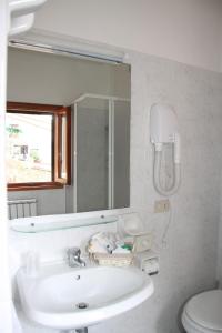 y baño con lavabo, espejo y aseo. en B&B L'Agnolo Di Caroti Cinzia, en Montepulciano