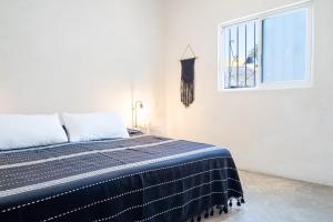 a bedroom with a bed and a window at Barbie Surf Shack - Walk to Everything in Sayulita +22 photos