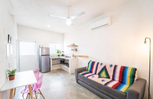 a living room with a couch and a kitchen at Barbie Surf Shack - Walk to Everything in Sayulita