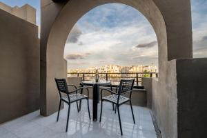 Un balcón con dos sillas y una mesa con vista. en Seaview Escape Summer Nights Guesthouse, en Marsaskala