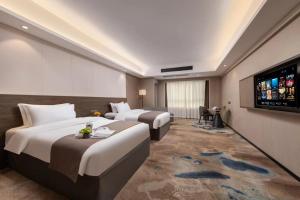 Voodi või voodid majutusasutuse Foshan Zhongying Holiday Hotel toas