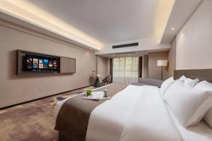 Voodi või voodid majutusasutuse Foshan Zhongying Holiday Hotel toas