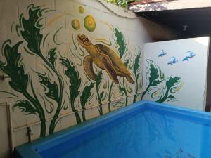 a mural of a sea turtle on a wall at OeNic! Hostal in Poneloya