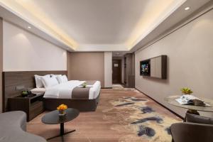 Voodi või voodid majutusasutuse Foshan Zhongying Holiday Hotel toas