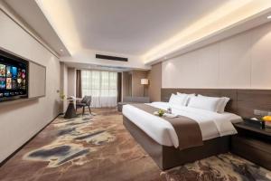 Voodi või voodid majutusasutuse Foshan Zhongying Holiday Hotel toas