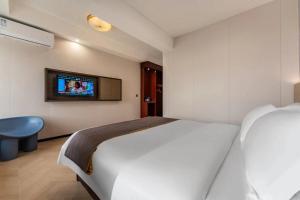 Voodi või voodid majutusasutuse Foshan Zhongying Holiday Hotel toas