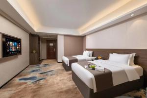 Voodi või voodid majutusasutuse Foshan Zhongying Holiday Hotel toas