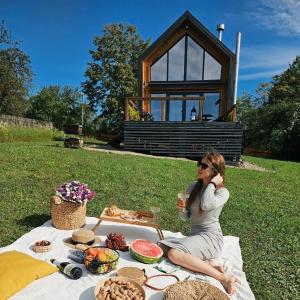 Starunyatbarn - Будинок з чаном в Карпатах - tranquilo barn的坐在野餐桌旁吃饭的女人